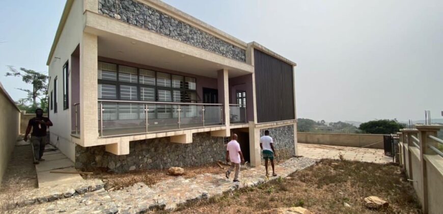Alert ultra modern 4 bedroom house with BQ , security post situated on 1.5 plots of land underground basement now selling at Aburi